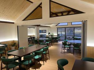 a dining room with tables and chairs and windows at Green Crown Resort in Yoliin Hural