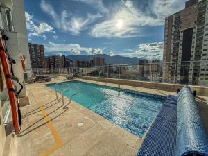 una piscina en la azotea de un edificio en Apartamento con vista a la montaña, piscina y gym, en Sabaneta