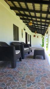 Habitación con sillas, mesas y techo. en Rancho Cali, Playa Las Hojas, El Salvador, en San Pedro Masahuat