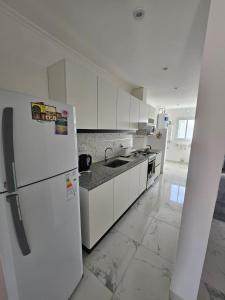 a kitchen with white cabinets and a white refrigerator at Rincon de Mayo in Tandil
