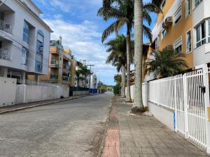 an empty street with palm trees and buildings at Cobertura com piscina e vista da Lagoa da Conceição in Florianópolis