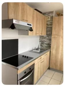 a kitchen with a black counter top and wooden cabinets at Meublé bord de Mer in Gravelines
