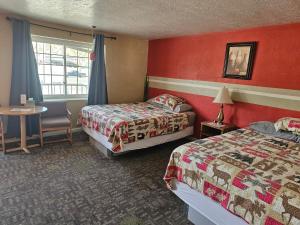 a hotel room with two beds and a table and a window at Two Rivers Inn in Thermopolis +26 photos