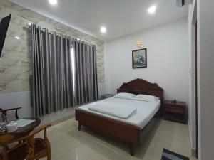 a bedroom with a bed and a large window at Khách sạn sen hồng 1 in Cao Lãnh