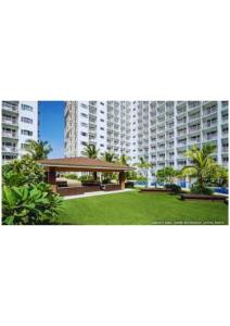 a large apartment building with a park in front of it at Stay Manila in Sampong