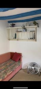 a room with a couch and a fan and shelves at Halima Guesthouse in Larache