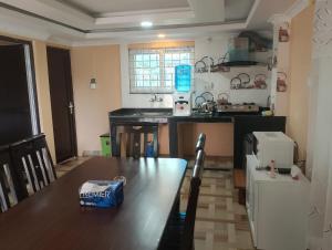 a kitchen with a wooden table and a kitchen with a counter at Annapurna View Apartment in Pokhara