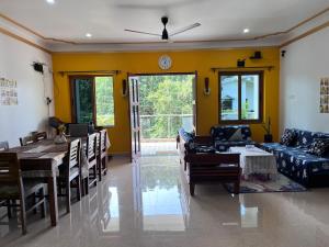 a living room with a table and a dining room at Happy Moon Homestay in Aldona