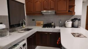 a kitchen with wooden cabinets and white counter tops at Detached 3 bed Villa, private pool - Nirvana Pool Villa 2 in Nong Prue