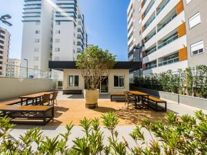 a patio with tables and chairs and buildings at Apartamento 5 estrelas próximo ao Shopping e USP in Bauru