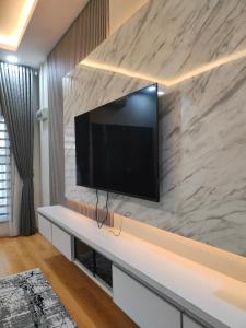 a living room with a tv on a marble wall at Homestay Saujana Hill in Gua Musang