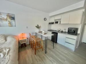 una cucina e un soggiorno con tavolo e sedie di L&M Suite Monoambiente a Belén de Escobar