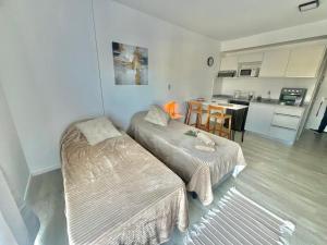 a small room with two beds and a kitchen at L&M Suite Monoambiente in Belén de Escobar