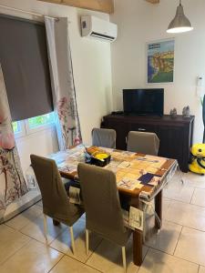 a dining room with a wooden table and chairs at Bonifacio tranquillité paradis in SantʼAmanza