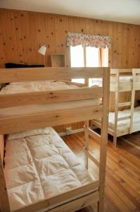 a bedroom with two bunk beds and a window at Ostello SanMartino in San Martino di Castrozza