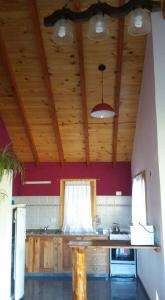 a kitchen with wooden ceilings and a table in a room at Cautiva Morena in San Martín de los Andes