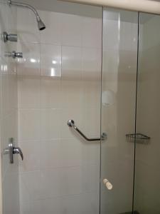 cabina de ducha con puerta de cristal y ducha en Condomínio Brasil 21 Torre D, en Brasilia