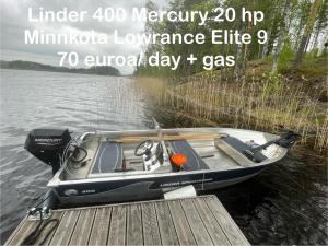 a small boat tied to a dock on the water at Saimaa Raikala in Vuoriniemi +52 photos