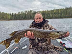 a man holding a large fish in a lake at Saimaa Raikala in Vuoriniemi