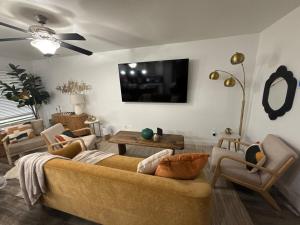 un soggiorno con divano, sedie e TV di Chic Comfort Restful Escape a Fort Worth