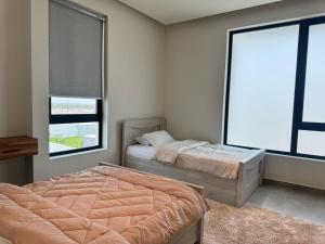 a bedroom with two beds and a window at Coming home chalet in Barka