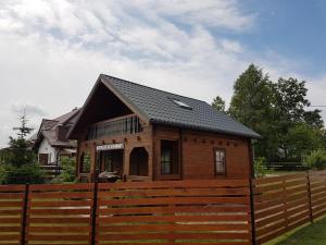 mały dom za drewnianym płotem w obiekcie Mazur House Bogaczewo w mieście Bogaczewo