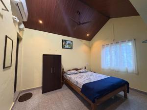 een slaapkamer met een bed in een kamer met een plafond bij Areca Nest in Gokarna