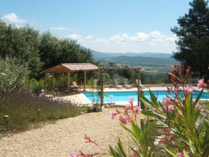 een zwembad met een prieel en uitzicht op een berg bij Les Cerises in Saint-Saturnin-dʼApt