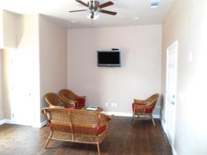 a living room with chairs and a tv on the wall at 2172-2178 main st in Morro Bay