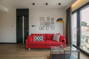 ソポトにあるGrand Apartments Wave- Na Faliのリビングルーム(赤いソファ、ガラステーブル付)