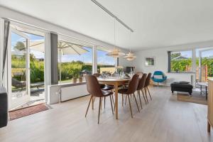 a dining room and living room with a table and chairs at Holiday Home In South Funen Near Beach in Fåborg
