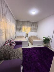 a bedroom with two beds and a purple rug at Apartment at Marassi in El Alamein