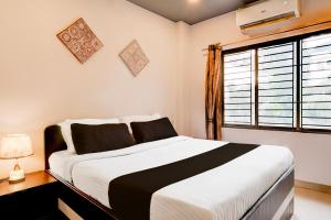 a bedroom with a large bed and a window at Townhouse Beltola Tiniali Formerly Hotel Pratishtha in Guwahati