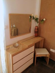a bathroom with a vanity with a mirror and a vase at Apart Mahdia in Mahdia