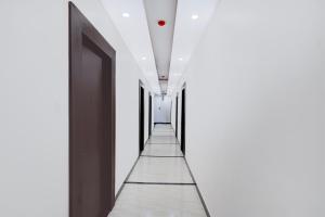 a hallway with white walls and a black door at Palette Hotel and Resort Sarnath Temple in Varanasi