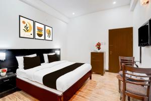 a bedroom with a large bed and a television at Palette by CheckIn Sarnath Temple in Varanasi