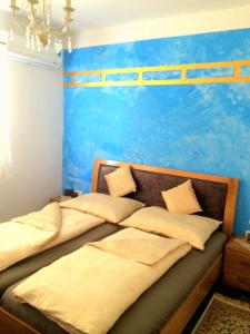 2 camas en un dormitorio con una pared azul en Apart Mahdia, en Mahdia