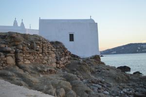 a building on the side of a rock wall at Camara Studio Mykonos in Ornos