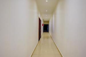 an empty hallway with a white wall and a door at Super Collection O Sanpada Railway Junction in Turambhe