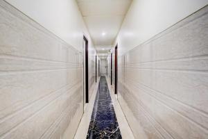 a corridor of a building with marble walls and a long hallway at Super Collection O Ulhasnagar Railway Station Formerly Hotel Derby in Kalyan