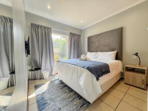 a bedroom with a bed and a large window at De'Lush Oasis in Pretoria