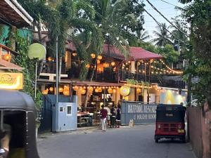 a building with people walking in front of it at Daffodil Restaurant & Holiday Resort in Unawatuna