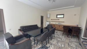 a living room with a table and chairs and a piano at Nurata Ecotourism Guesthouse in Yukary-Ukhum
