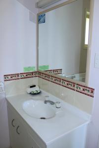 a bathroom with a white sink and a mirror at Kilcoy Gardens Motel in Kilcoy