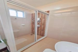 a bathroom with a shower and a toilet at INATO SUITES Rm 2 2 queen beds in Panglao Island