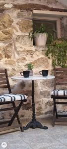 a table with two bowls on it next to two chairs at St Thomas House in Adhráktia