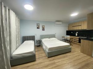 een slaapkamer met twee bedden en een keuken met een piano bij Kriss-Klej's Rooms in Sarandë