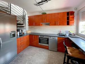 a kitchen with wooden cabinets and a stainless steel refrigerator at Bem in Kecskemét
