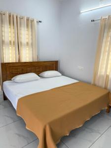 a bedroom with a large bed with two pillows at Joseph's Residency Homestay in Podanūr +11 photos