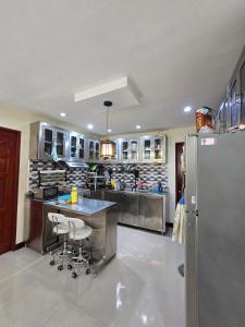 a large kitchen with a counter and a refrigerator at Beautiful four bedroom home in Talisay